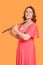 Portrait of a woman musician with a flute on a studio yellow background. Flutist with a large concert transverse flute in her