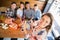 Portrait of woman photographing friends in restaurant