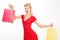 Portrait woman in pin up style red dress holding shopping bags. Sales, consumer, retro fashion. Beautiful blonde woman