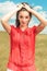 Portrait of woman posing in the fields with her hands fixing her