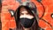 Portrait of a woman in a protective black mask outdoors near an old broken wall. Coronavirus and air pollution concept. A girl