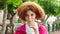 Portrait of a woman with a red afro drink from a straw while standing against a urban background. Edgy young female