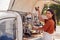 Portrait Of Woman Running Independent Mobile Coffee Shop Making Drink Standing Outdoors Next To Van