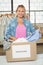 Portrait of woman separating clothes from donation box in office