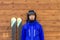 Portrait woman skier with skis and helmet near wooden wall