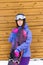 Portrait woman with snowboard and hat and splitboard near wooden wall