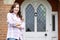 Portrait Of Woman Standing Outside Front Door Of Home