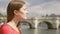 Portrait of woman standing on waterfront in Paris. Young lonely tourist travelling through Europe