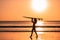 Portrait of woman surfer with beautiful body on the beach with surfboard at colorful sunset