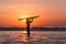 Portrait of woman surfer with beautiful body on the beach with surfboard at colorful sunset