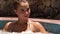 Portrait woman taking jacuzzi bath in luxury spa. Face young woman bathing in jacuzzi spa while resting in luxury resort
