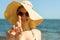 Portrait of woman taking skincare with sunscreen lotion at beach