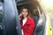 Portrait of a woman talking on cell phone sitting on a driver seat in her car