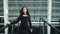 Portrait woman touching hair outside. Business woman smiling on stairs outdoors