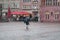 Portrait of woman with umbrella Crossing a paved square in the city