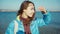 Portrait woman walking outdoors at sea side at sunny day wind blowing hair