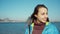 Portrait woman walking outdoors at sea side at sunny day wind blowing hair