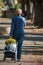 Portrait of woman walking with yellow chrysanthemums flowers on trolley at cemetery