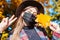 Portrait of woman wearing mask in fall park during coronavirus covid-19 pandemic and taking selfie. Stylish autumn