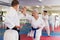 Portrait of woman wearing white kimono sparring with male opponent during martial arts training