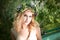 Portrait of woman with wreath sitting in boat with flowers. Summer