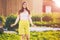 Portrait of woman in yellow Bermuda shorts, white female 26 years old posing for photographer near country house in