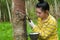 Portrait women tapping latex from a rubber tree