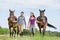 Portrait of women walking while talking with their horses in ranch