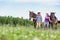 Portrait of women walking while talking with their horses in ranch