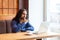 Portrait of wondering handsome bearded intelligence young adult man freelancer in casual style sitting in cafe and writting a book