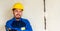 Portrait of worker or engineer in blue work clothes and yellow safety helmet