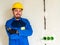 Portrait of worker or engineer in blue work clothes and yellow safety helmet