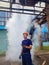 Portrait of a worker in a factory. Steam under pressure in the background. in a helmet and gloves examines the territory of the