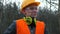 Portrait worker with glasses, hard hat. Headphones worn around neck.