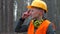 Portrait worker in helmet and glasses. Headphones around neck.