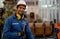 Portrait of worker or technician man hold wrench, smile and stand in front of copper pipe in factory