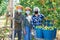 Portrait of workers in masks posing with harvested pears in garden