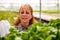 Portrait of a working woman looking at a crate with salad