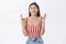 Portrait of worried intense attractive caucasian fair-haired female model in striped top and headband standing with