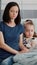 Portrait of worried mother sittting beside hospitalized little child looking into camera