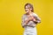 Portrait of worried sick woman with fair hair in casual beige blouse, isolated on yellow background