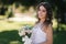 Portrait of yound girl with bouquet. Charming lady in sunny summer day. Stylish woman