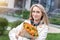 Portrait young adult smiling classy woman model hand holding authentic fresh orange spray roses flower bouquet wrapped in craft