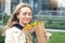 Portrait young adult smiling classy woman model hand holding authentic fresh orange spray roses flower bouquet wrapped in craft