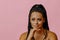 portrait of young adult thoughtful beauty black woman with hand on chin braid hair on pink background