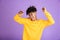 Portrait of young african american boy having stylish afro hairdo dancing and singing, while listening to music via bluetooth ear