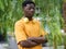 Portrait of a young african american man with glasses looking at camera seriously with vegetation in the background