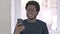 Portrait of Young African American Man Shocked using Smartphone