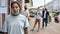 Portrait of young african american woman with mask on her chin looking at camera. People waiting in line, respecting