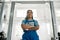 Portrait of young african american woman, professional female mechanic in uniform looking away, standing in auto repair